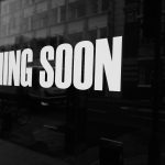 a black and white photo of a sign that says coming soon